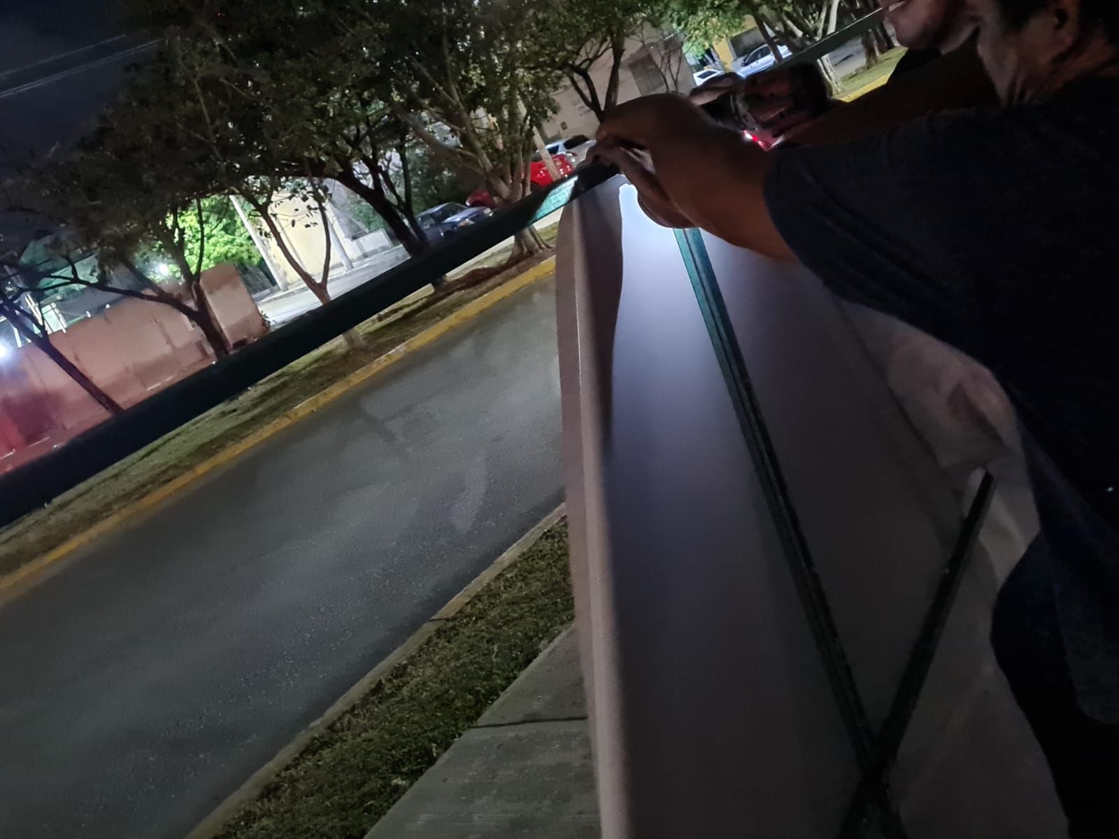 Instalación nocturna de lona publicitaria en obra
