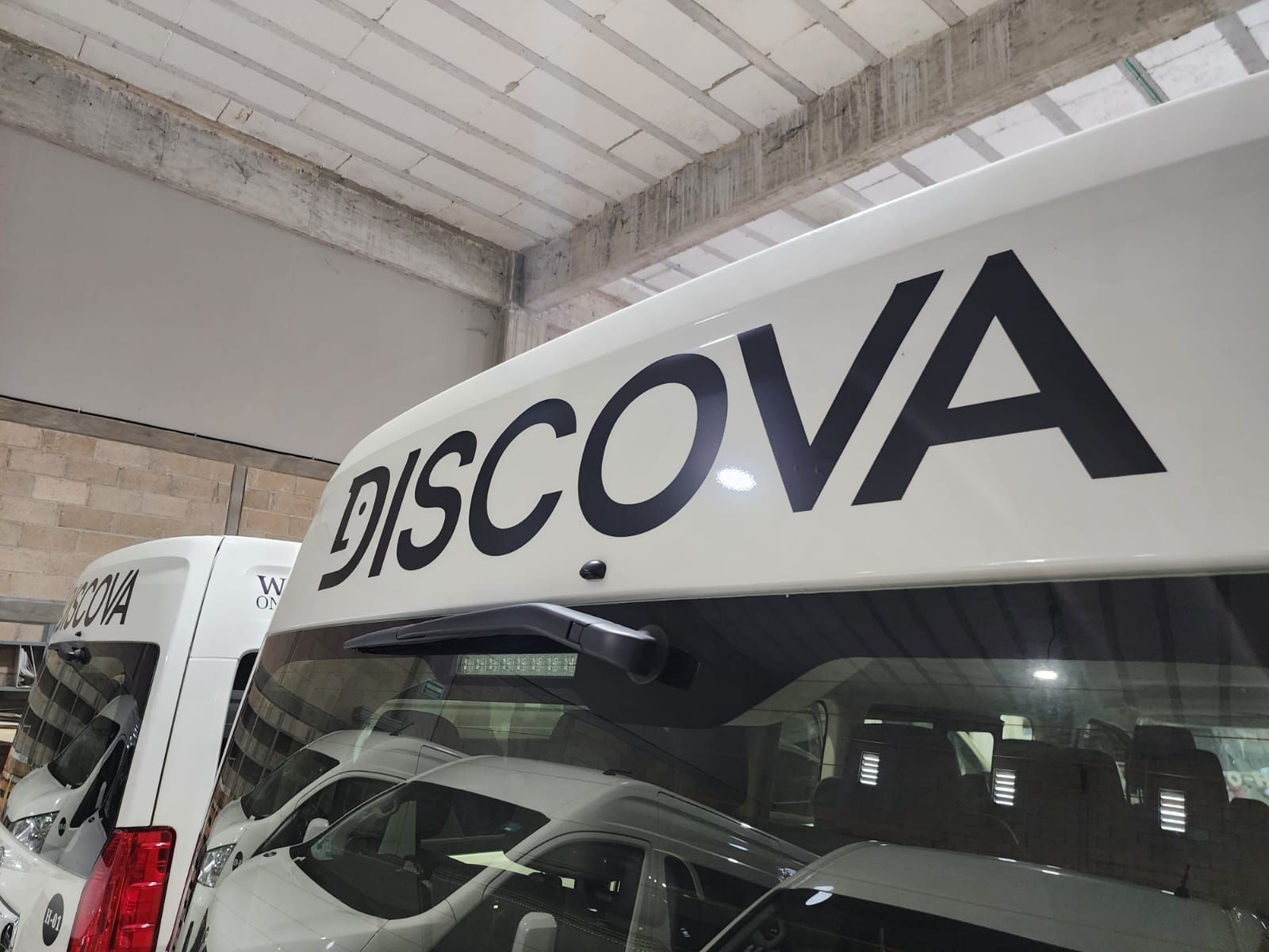 Camioneta de turismo con rotulación de marca en taller